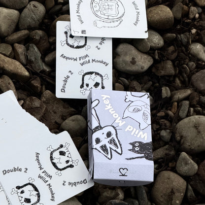Wild Monkey Playing Cards and tuck box on rocks